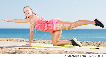 vigorous young female exercising on exercise mat outdoor vigorous young female exercising on exercise mat outdoor 67076811