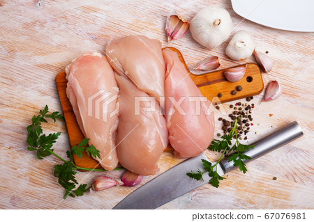 Uncooked raw chicken breast fillet with parsley and garlic Uncooked raw chicken breast fillet with parsley and garlic 67076981