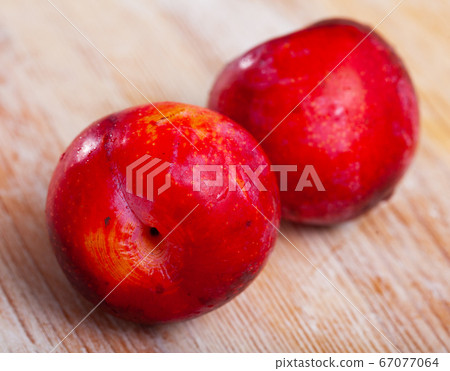 Sweet red plums on wooden table Sweet red plums on wooden table 67077064