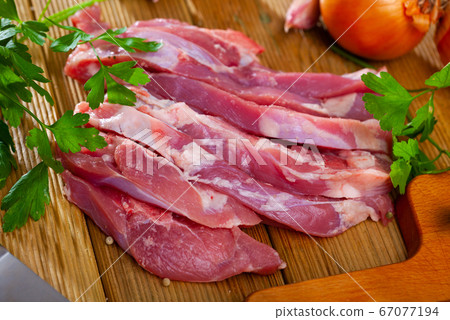 Raw uncooked turkey thighs with onion and greens 67077194