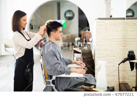 Hairdresser cut male's hair in hairdressing salon 67077221
