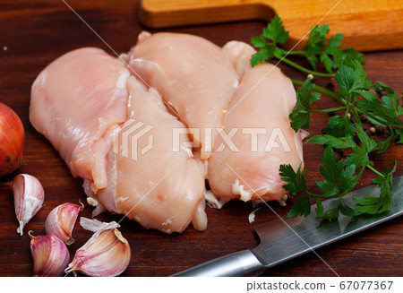 Raw chicken breast on wooden table Raw chicken breast on wooden table 67077367