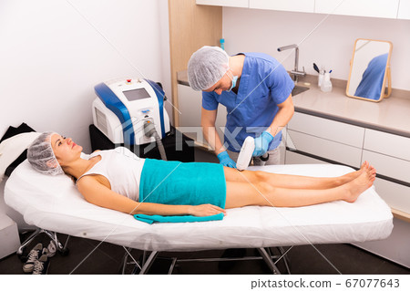 Woman getting laser hair removal 67077643