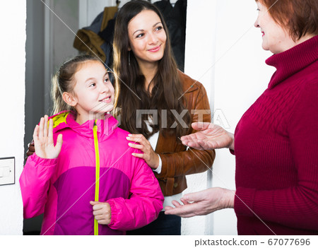 Girl with mother visiting her grandmother Girl with mother visiting her grandmother 67077696