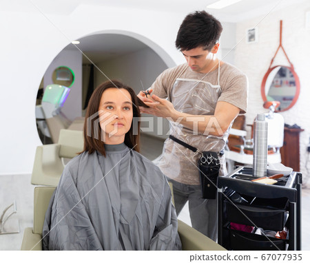 Young guy professional hairdresser cut woman's hair Young guy professional hairdresser cut woman's hair 67077935