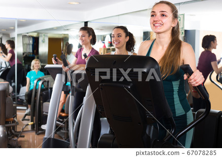 Women using cross-trainers in sport club . 67078285