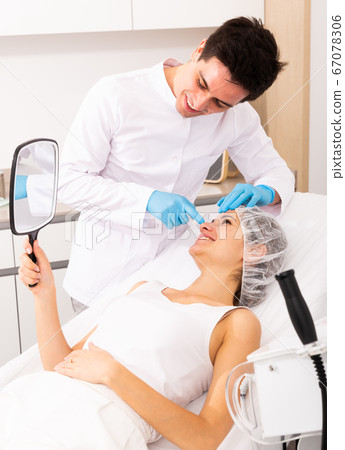 Cosmetologist giving consultation to woman patient Cosmetologist giving consultation to woman patient 67078306