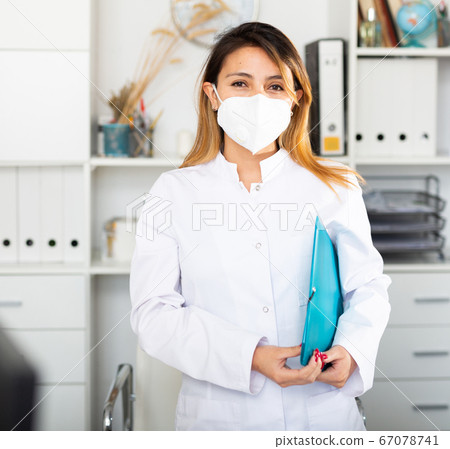 Colombian female medical mask in uniform holding clipboard 67078741