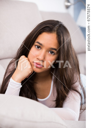 young female sad and thinking on sofa 67078874