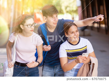 Teenage friends enjoying walk around city in summer Teenage friends enjoying walk around city in summer 67078875