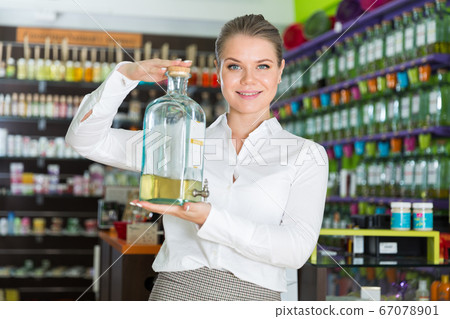 Saleswoman with big bottle of perfume 67078901