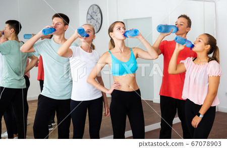 Teens drinking water on break during dancing training Teens drinking water on break during dancing training 67078903