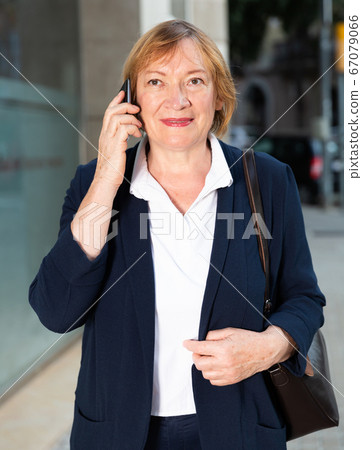 Woman talking on smartphone on street 67079066