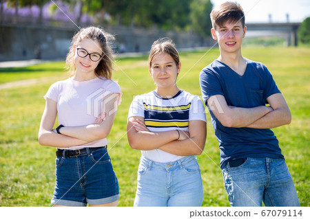 Three happy confident teenagers in summer city park Three happy confident teenagers in summer city park 67079114
