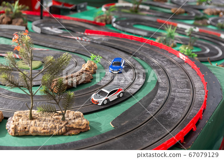 Electric slot cars on toy race track 67079129