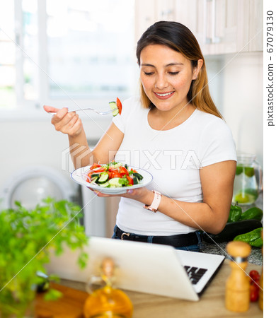 Nice latino woman planning to cook, looking for recipe on internet 67079130
