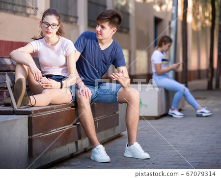Boy and girl look at the screen of a smartphone Boy and girl look at the screen of a smartphone 67079314