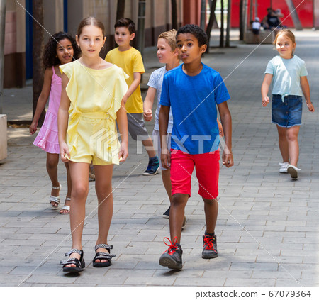 Positive little mexican boy and his friend girl walking together Positive little mexican boy and his friend girl walking together 67079364