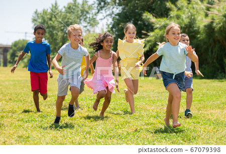 Cheerful kids are jogging together in the park 67079398