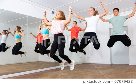 Happy teens jumping in choreography class Happy teens jumping in choreography class 67079428