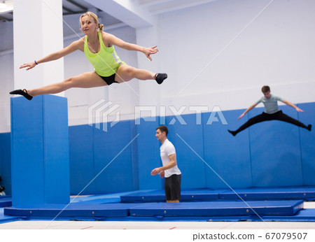 Woman jumping in trampoline center Woman jumping in trampoline center 67079507