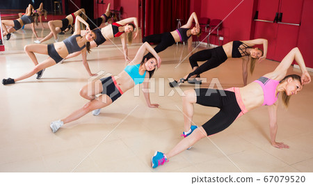 cheerful women performing modern dance in fitness studio cheerful women performing modern dance in fitness studio 67079520