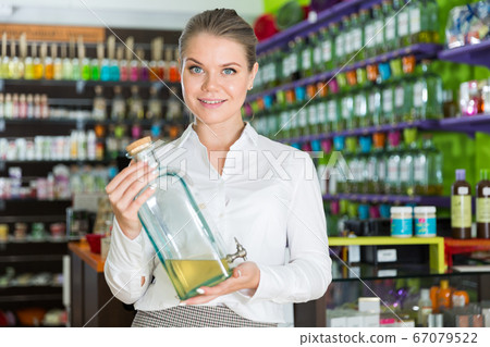 Female seller showing large perfume bottle Female seller showing large perfume bottle 67079522