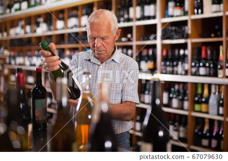 Fine man visiting winehouse in search of wine Fine man visiting winehouse in search of wine 67079630