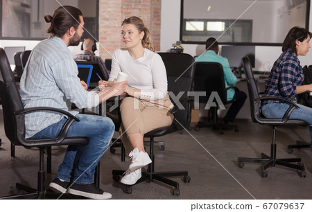 Girl and young man talking in coworking space Girl and young man talking in coworking space 67079637