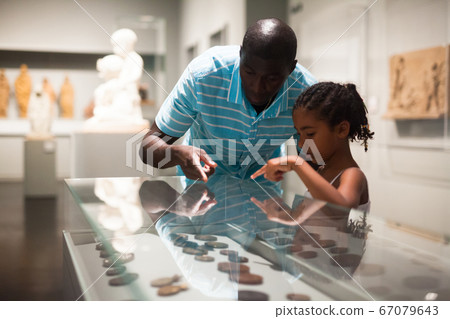 Visitors looking at exhibits in glass stands Visitors looking at exhibits in glass stands 67079643