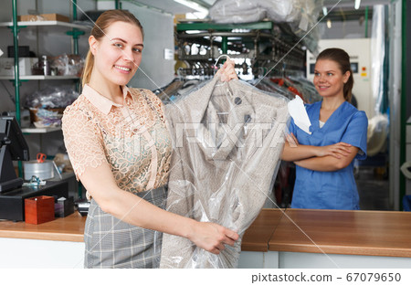 Satisfied client of laundry with clean garment 67079650