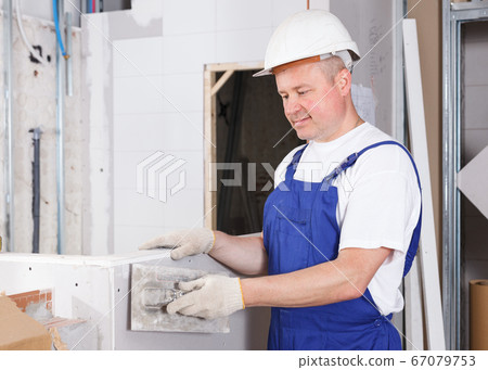 Plasterer taping drywall joints 67079753