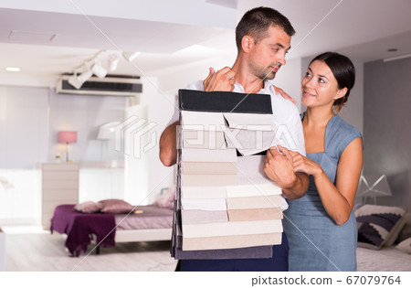 Couple choosing furniture materials in showroom 67079764
