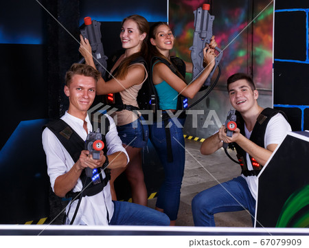 happy girls and guys in dark laser tag room 67079909
