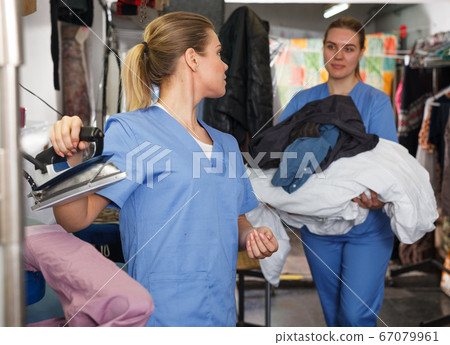 Girl ironing clothes after dry cleaning 67079961