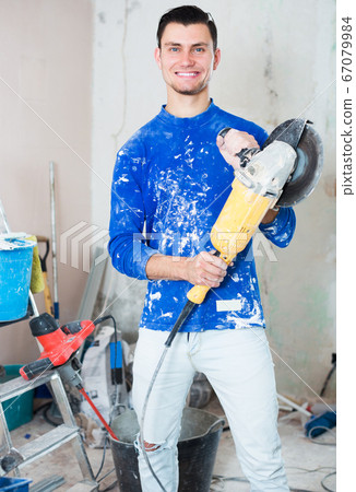 Male using professional angle grinder 67079984