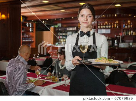 Smiling waitress with serving tray Smiling waitress with serving tray 67079989