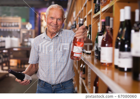 Glad man visiting winehouse in search of wine Glad man visiting winehouse in search of wine 67080060