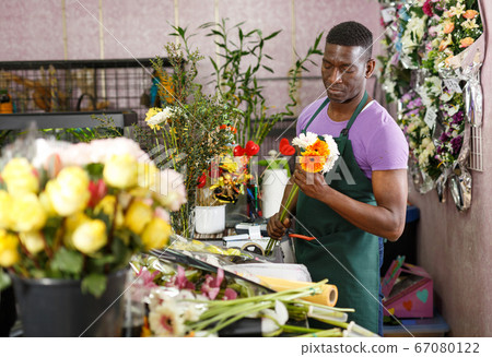 Florist making bouquet with gerberas 67080122