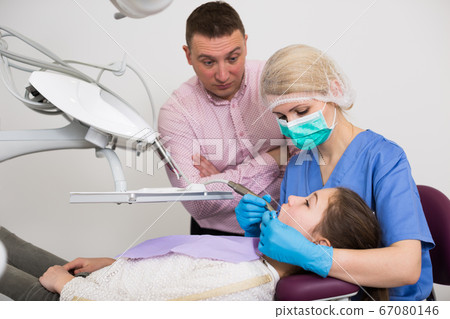 Worried father with daughter during dental treatment 67080146
