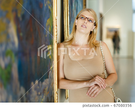 Woman wearing glasses looking at pictures Woman wearing glasses looking at pictures 67080356