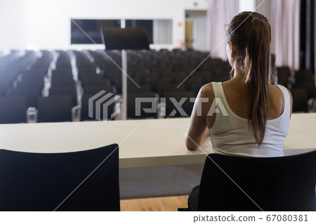 Woman sitting opposite to empty hall 67080381