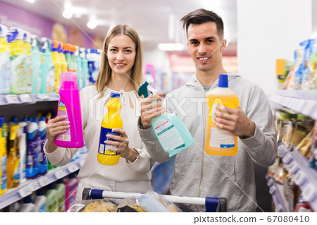 Fine couple choosing household detergents Fine couple choosing household detergents 67080410