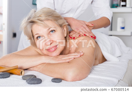 Mature woman having massage Mature woman having massage 67080514