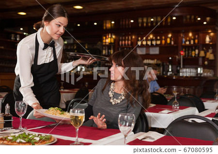 Dissatisfied female client with waitress 67080595