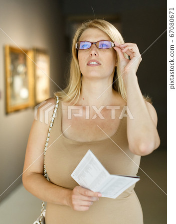 Woman holding brochure in museum of arts 67080671
