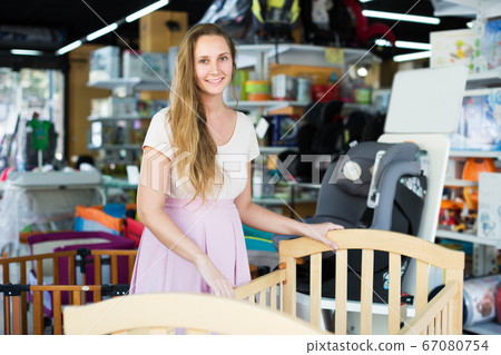 Pregnant woman choosing cradle Pregnant woman choosing cradle 67080754