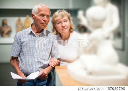Couple holding brochure at museum Couple holding brochure at museum 67080798