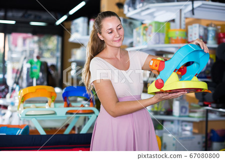 Pregnant woman choosing baby chair Pregnant woman choosing baby chair 67080800