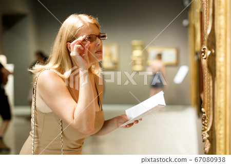 Woman holding brochure in museum of arts Woman holding brochure in museum of arts 67080938
